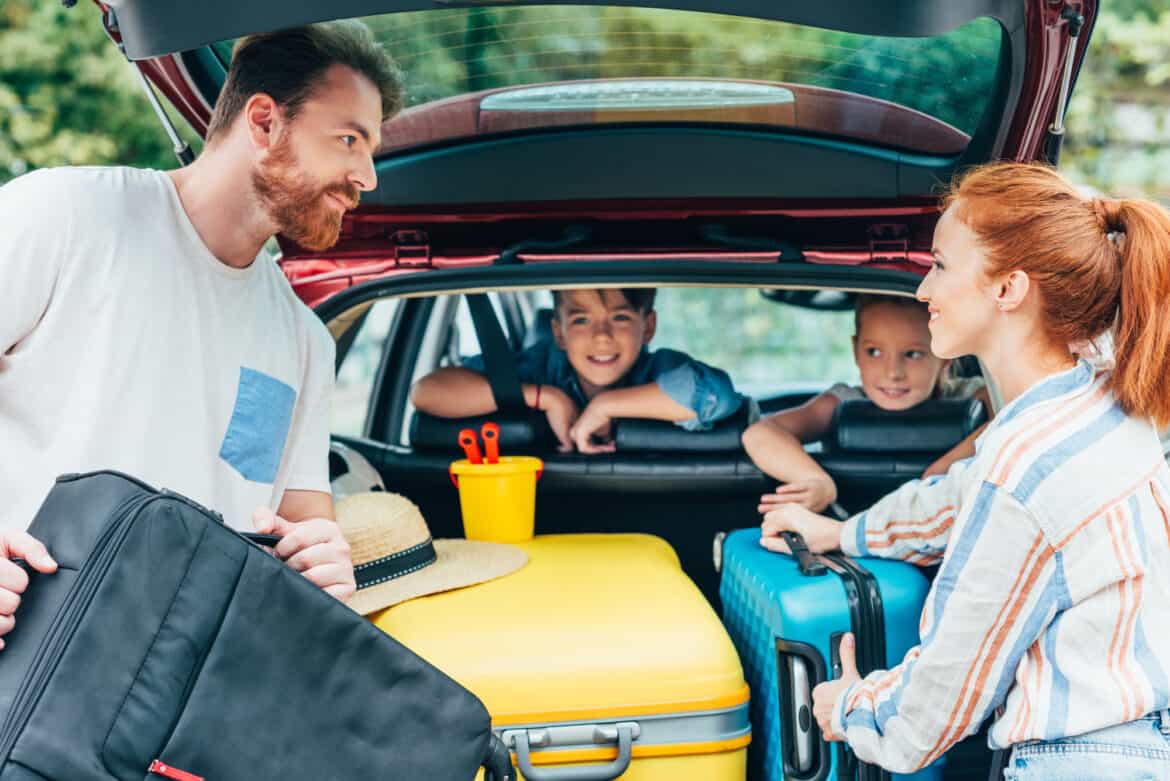 familie med to børn er ved at pakke bilen med kufferter på vej på bilferie ferie familie med to børn er ved at pakke bilen med kufferter på vej på bilferie ferie